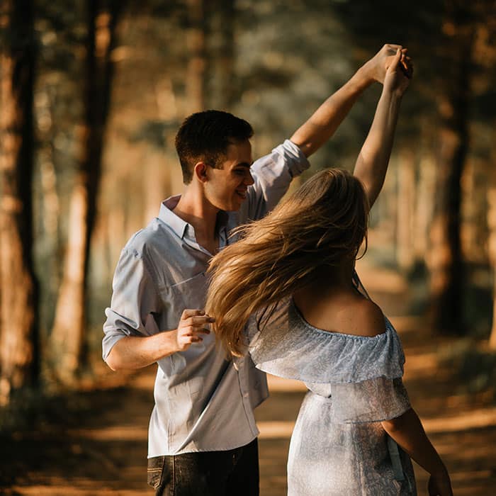 Histoire d'amour à distance joli couple qui danse en forêt