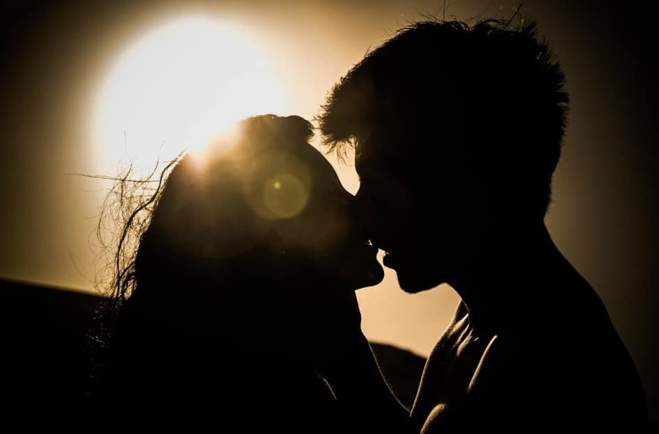 joli couple s'embrasse sur un lieux de rencontre amoureux avec un magnifique coucher de soleil